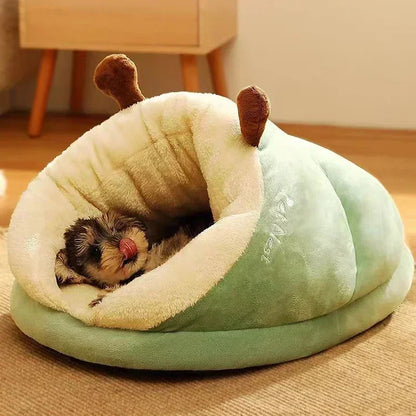 Cat curled inside a green plush cocoon pet bed