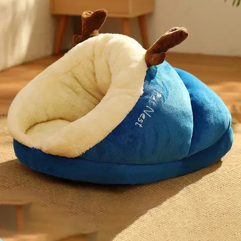 Gray cat sleeping in a green plush cocoon pet bed
