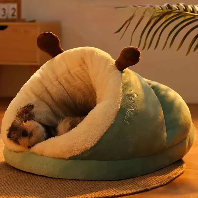 Kitten resting in a green plush cocoon pet bed