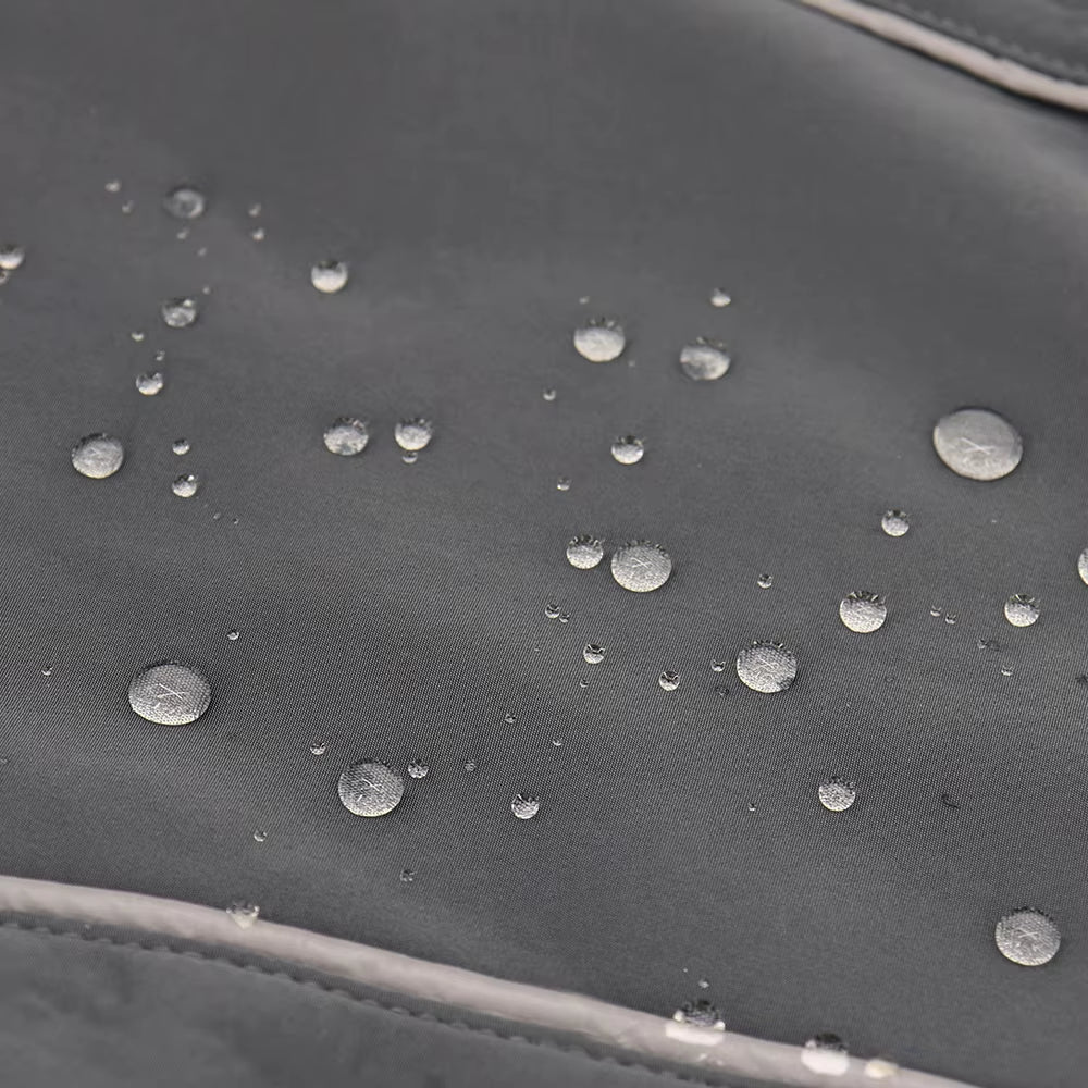 Water droplets beading on the black waterproof shell of the dog coat