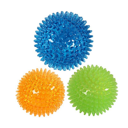Three spiky squeaky dog balls in bright colors