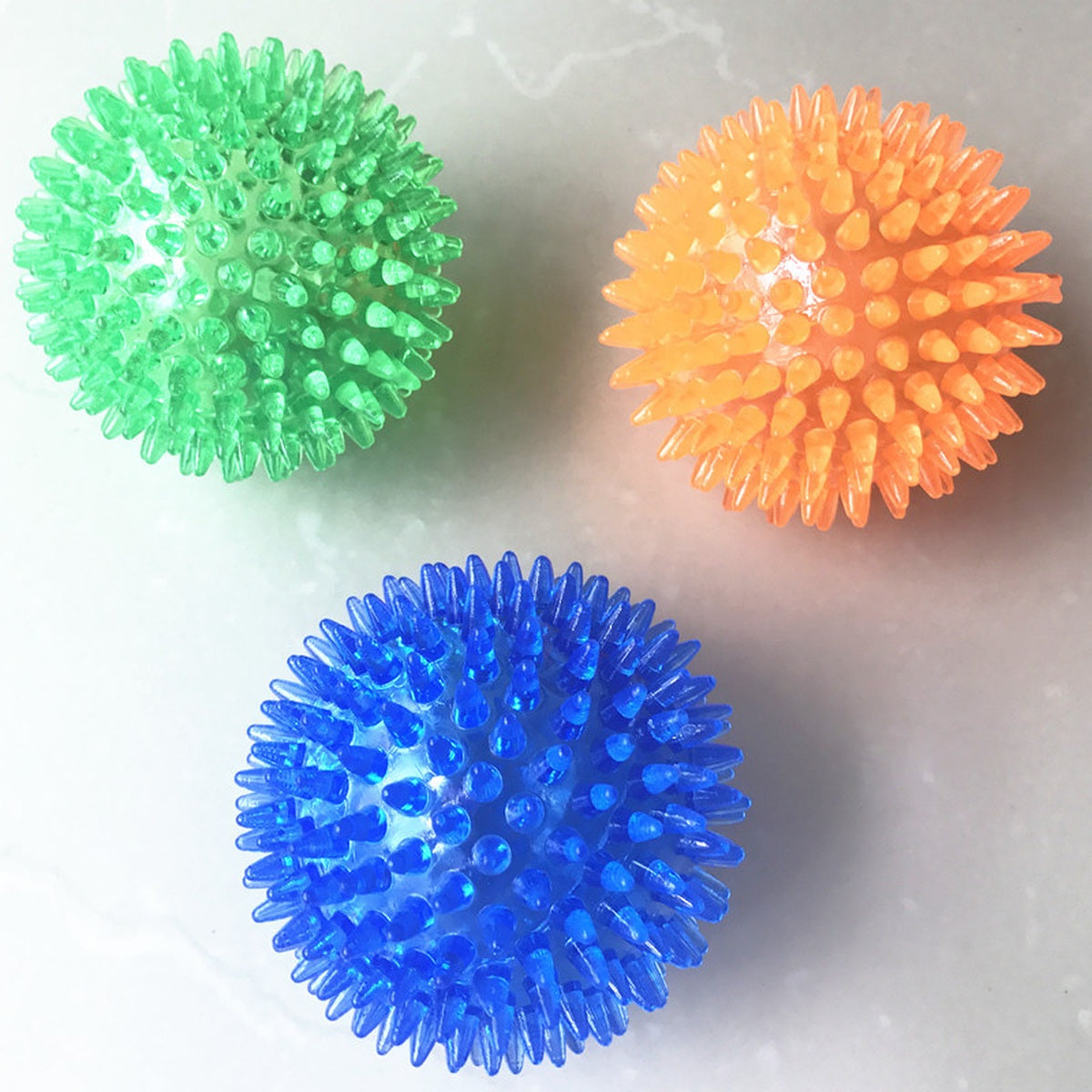 Green red and yellow spiky squeaky dog balls