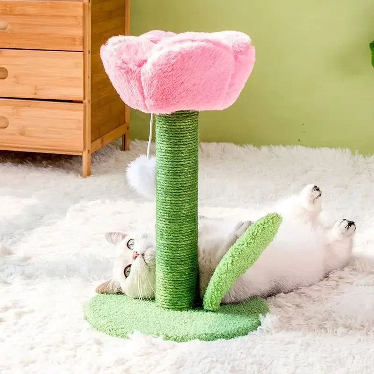 White cat playing on a pink tulip-shaped cat tower